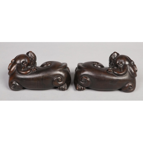 181 - A pair of Chinese carved hardwood lion dogs in recumbent pose c.1900, 22cm.