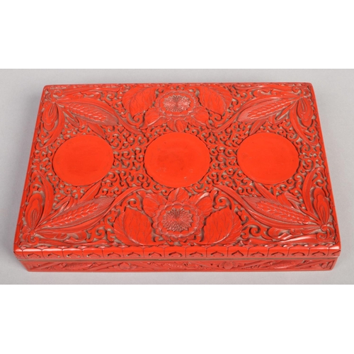 201 - A Chinese cinnabar lacquer rectangular box and cover. Decorated in relief with peonies and ears of c... 