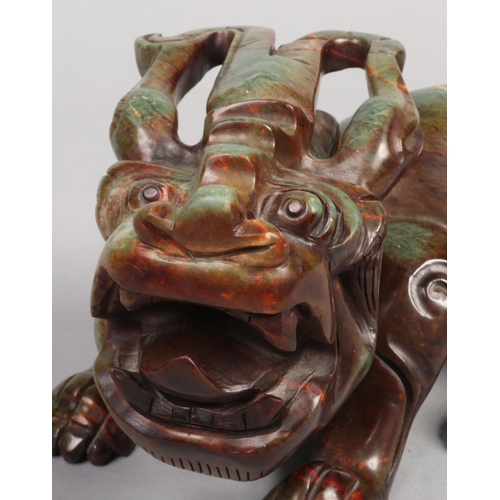 212 - An early 20th century Chinese carved hardstone model of a horned recumbent beast, 26cm long.