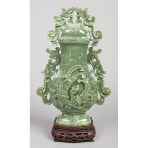 237 - A Chinese nephrite baluster vase and cover on hardwood stand. With open flat scrolling handles forme... 