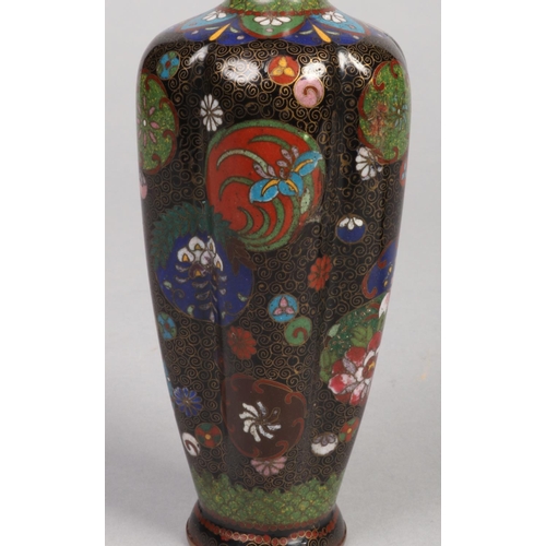 239 - A pair of Japanese Meiji period cloisonne vases of fluted form. Decorated on black grounds with roun... 