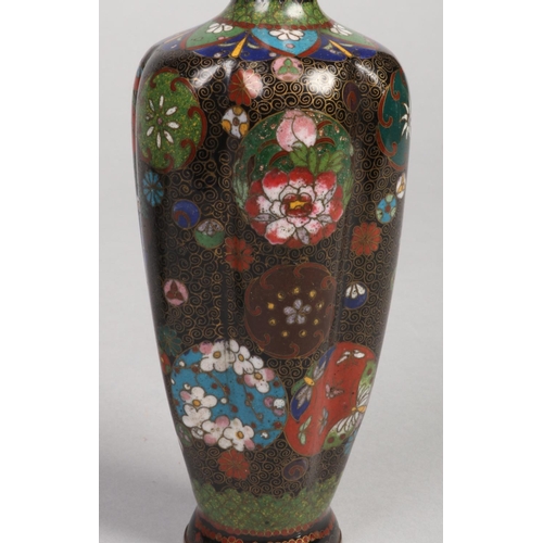 239 - A pair of Japanese Meiji period cloisonne vases of fluted form. Decorated on black grounds with roun... 