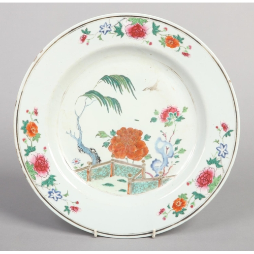 241 - An 18th century Chinese charger. Decorated in coloured enamels with a fenced garden landscape and fu... 