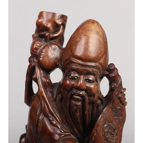 246 - An early 20th century Chinese carved hardwood figural tablelamp base formed as a sage. Stood holding... 