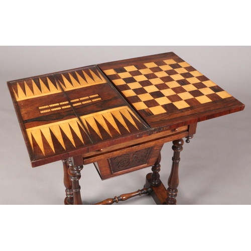 697 - A Victorian rosewood work table raised on turned supports. With fold over inlaid gaming top, 75cm hi... 