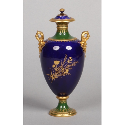 120 - A fine Royal Crown Derby twin handled pedestal urn and cover by Desire Leroy. With raised gilding on... 