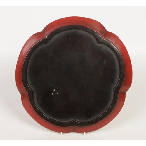 225 - A Chinese lobed cinnabar lacquer dish. Decorated in low relief with stylized scrolls, 34cm wide.