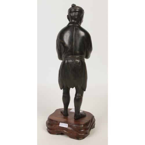 184 - A Japanese Meiji period bronze statue raised on a wooden plinth. Formed as a man holding a pipe and ... 