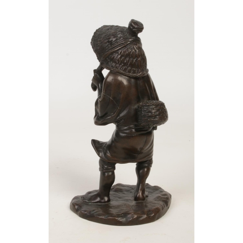 227 - A Japanese Meiji period patinated bronze figure of a farmer. Modelled pulling his coolie hat firmly ... 