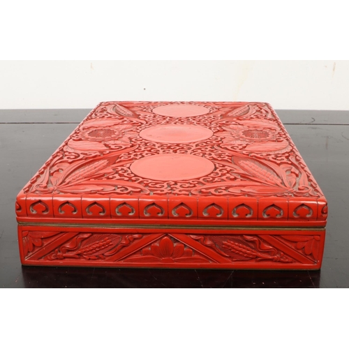 201 - A Chinese cinnabar lacquer rectangular box and cover. Decorated in relief with peonies and ears of c... 