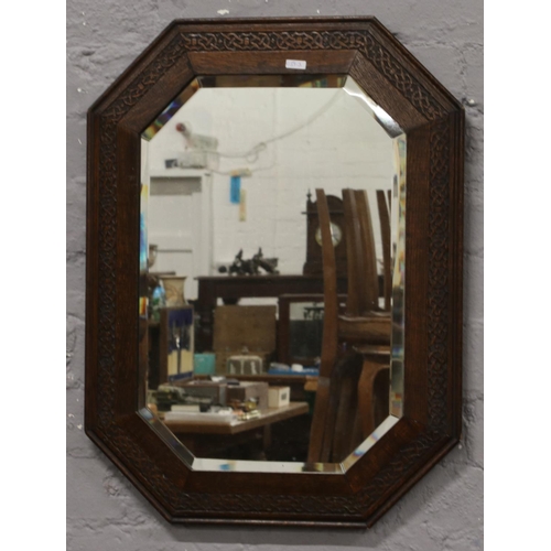 64 - A carved oak bevel edge wall mirror.