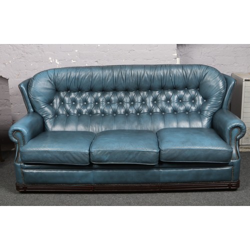 740 - A blue leather Chesterfield high back settee, 184cm.