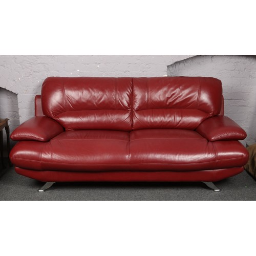 743 - A modernist red leather and chrome three seater settee and armchair raised on splay supports.