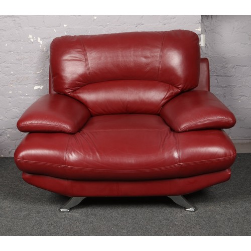 743 - A modernist red leather and chrome three seater settee and armchair raised on splay supports.