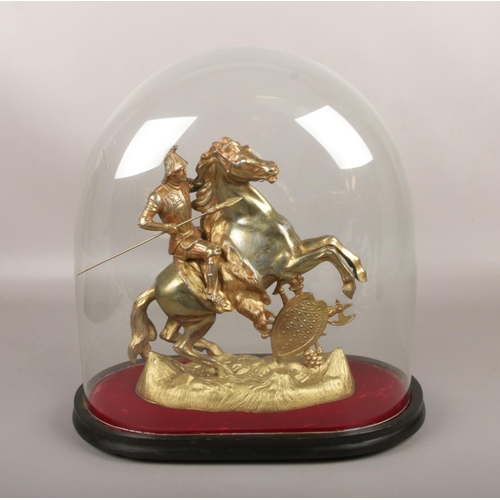 42 - A gilt metal figure of a knight on horseback, under Victorian glass dome.