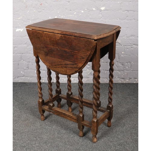 643 - A small oak drop leaf table with barley twist supports.