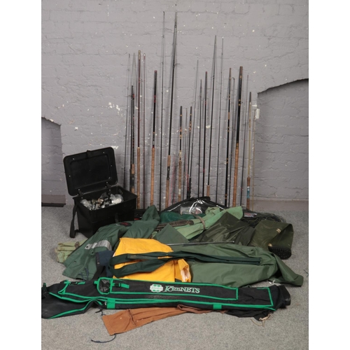 575 - A large quantity of fish equipment to include fishing box, reels, rods, clothing, keep net etc.