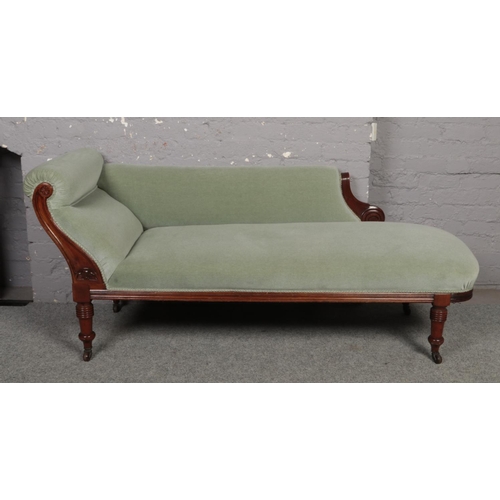 636 - A Victorian carved mahogany chaise lounge on turned supports.