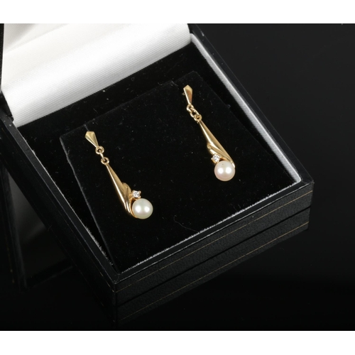 444 - A pair of cased 9ct gold pearl and diamond pendant earrings.