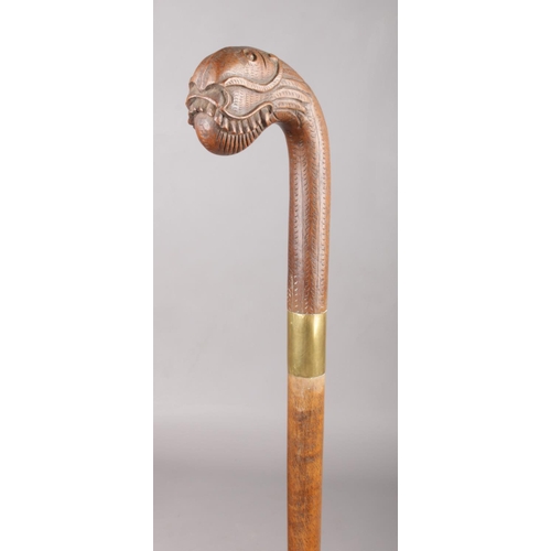 161 - A walking stick with brass collar and Oriental carved hardwood terminal formed as a dragon, possibly... 