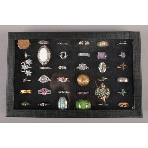 111 - A display case with contents of 36 white and yellow metal dress rings.