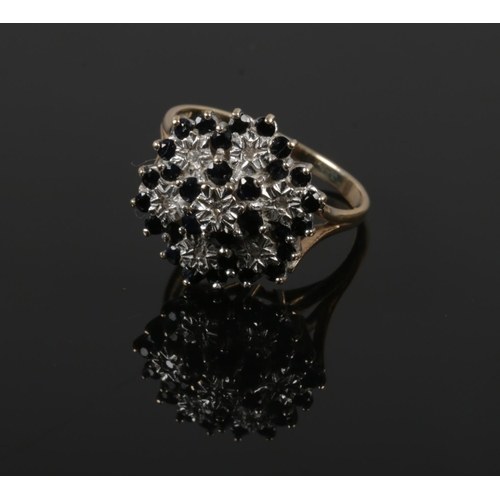 402 - A large 9ct gold sapphire and diamond snowflake cluster ring. Size R 1/2.