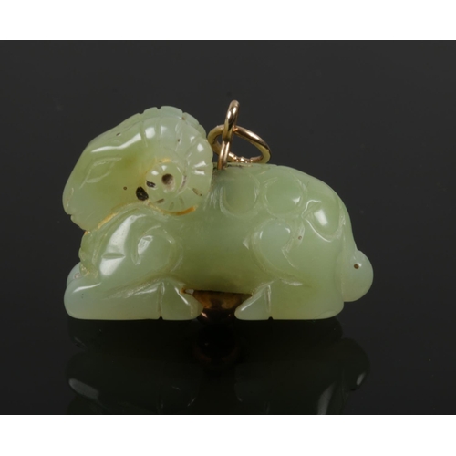 414 - A Chinese Qing dynasty carved pale celadon jade carving of a recumbent ram. Drilled and on a later a... 