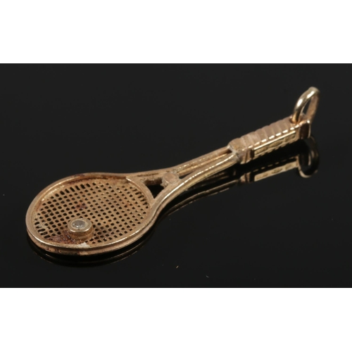 422 - A 9ct gold pendant formed as a tennis racket, set with a single diamond. (2.59g).