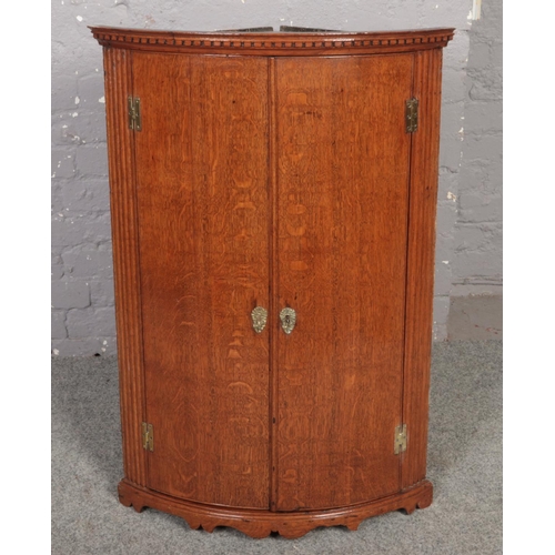 641 - A Georgian carved oak wall mounted corner cupboard, 100cm x 66cm.