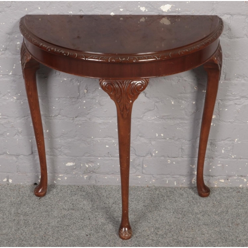 642 - A carved mahogany demi lun side table.