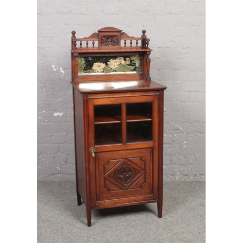 670 - A Victorian mahogany music cabinet. With mirror back painted with water lilies, astragal glazed door... 