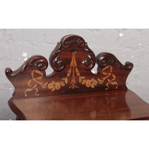 671 - An Edwardian mahogany coal perdonium. With carved scroll pediment, mirrored back, having marquetry i... 