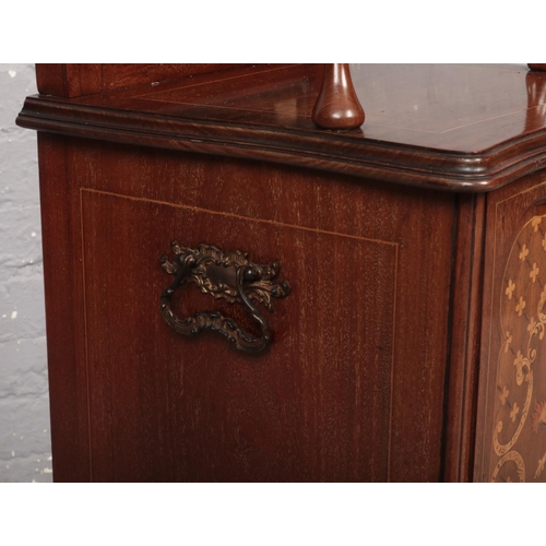 671 - An Edwardian mahogany coal perdonium. With carved scroll pediment, mirrored back, having marquetry i... 