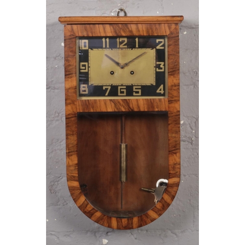 380 - An Art Deco walnut cased 8 day wall clock. With black and gilt rectangular dial and striking on a go... 