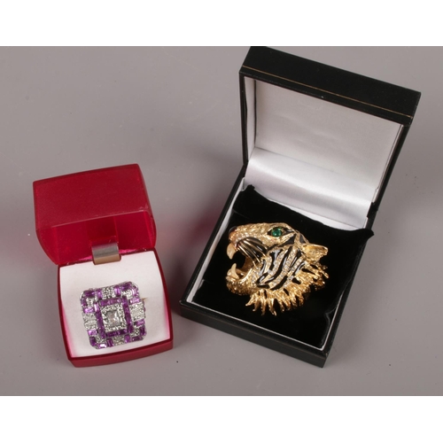 453 - A yellow metal Butler & Wilson tiger brooch, along with a white metal paste set dress ring.