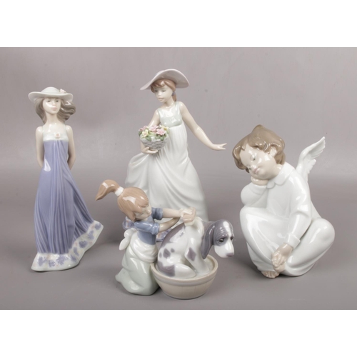 553 - Four Lladro figures to include girl bathing dog, girl with flowers etc.