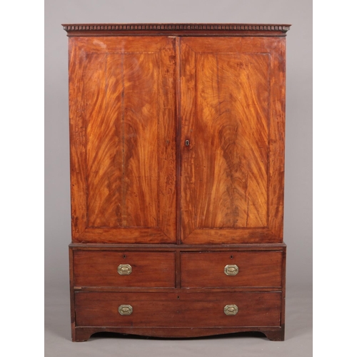 275 - A George III figured mahogany cottage linen press raised on a three drawer base. With oak carcass, d... 