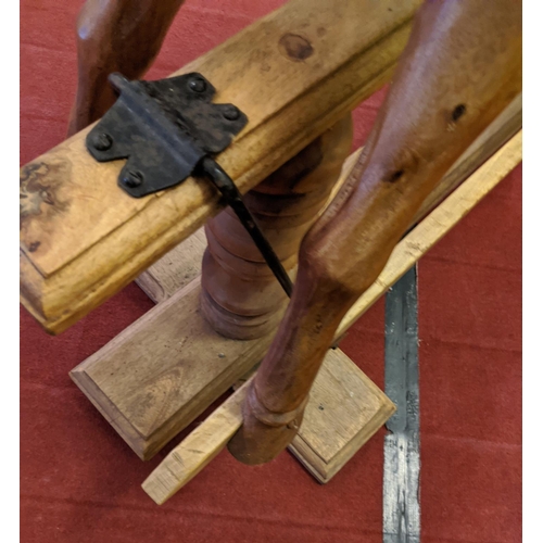 253 - A large carved hardwood child's rocking horse with leather saddle and bridle, 105cm high.