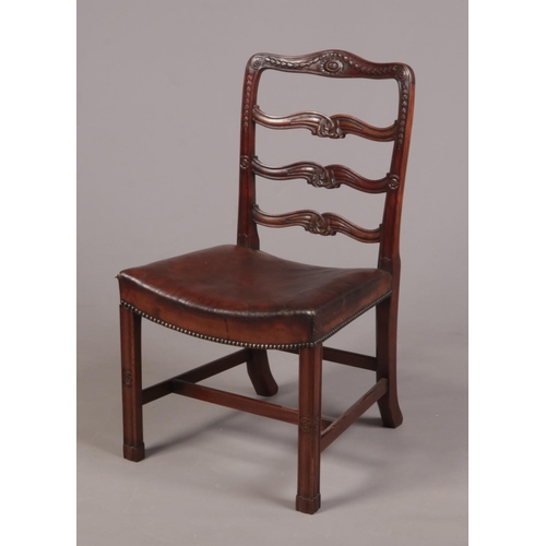 256 - A 19th century carved mahogany ladder back side chair. Decorated with husk swags, medallions and scr... 