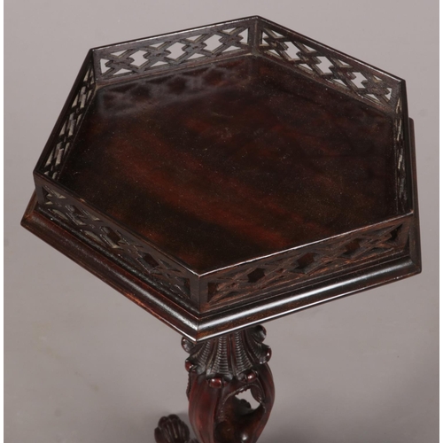 281 - A Chippendale style mahogany wine table with hexagonal top having open fret gallery. Raised on an op... 