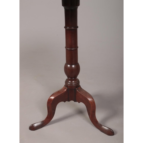 284 - A George III mahogany dish topped tripod wine table. Raised on a gun barrel column over three cabrio... 