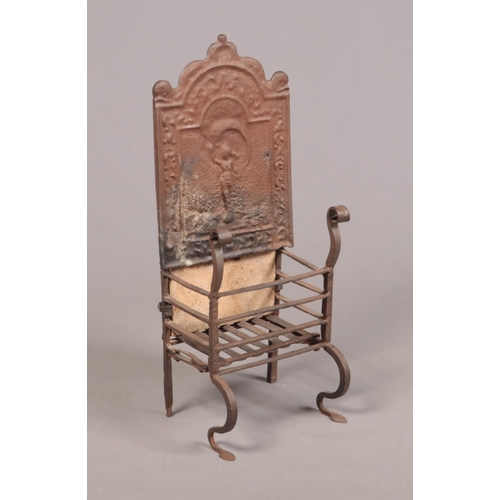 80 - An 18th century wrought iron fire grate. The arch top back decorated in relief with a figure and rai... 