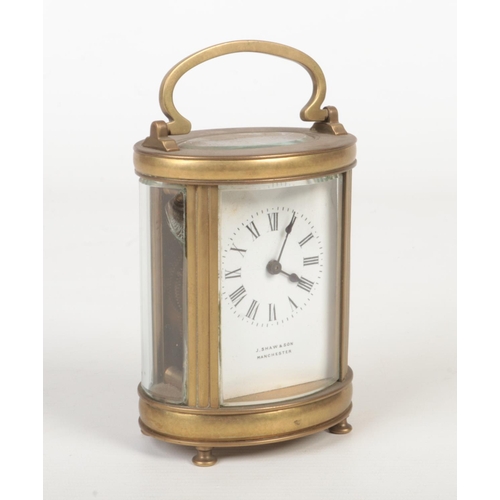 64 - A 19th century oval brass carriage clock retailed by J. Shaw & Son, Manchester. With enamel dial and... 