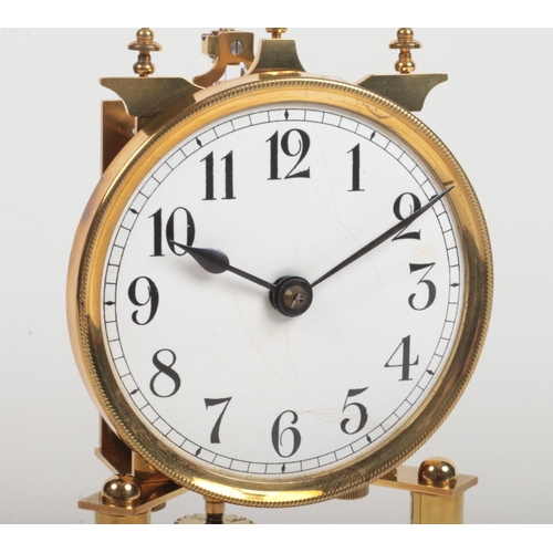 69 - An early 20th century brass torsion clock under glass dome. With white enamel dial having Arabic num... 