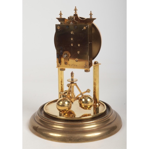 69 - An early 20th century brass torsion clock under glass dome. With white enamel dial having Arabic num... 