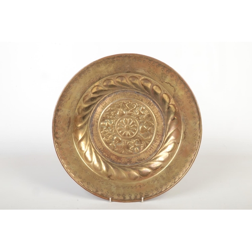 78 - A 17th century brass alms dish. Embossed with a rosette centre under a gadrooned well and with a pun... 