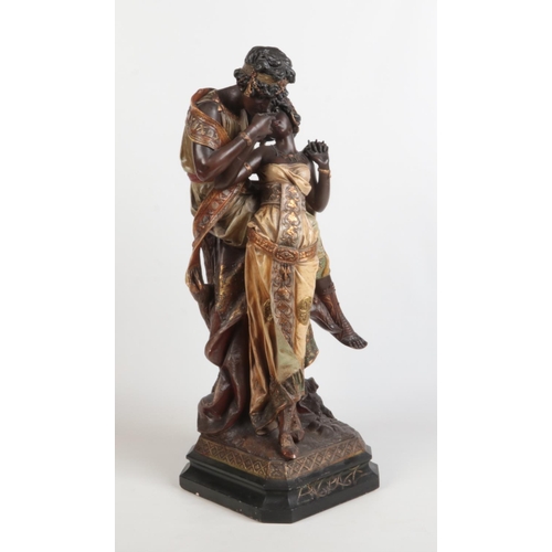 88 - A large Art Nouveau painted terracotta figure group. Odalisque and companion. Raised on a canted squ... 