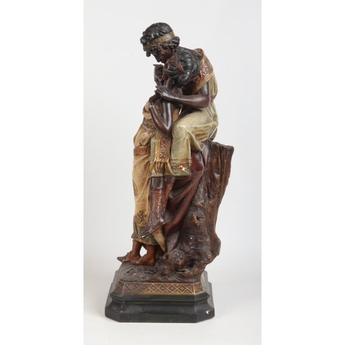 88 - A large Art Nouveau painted terracotta figure group. Odalisque and companion. Raised on a canted squ... 