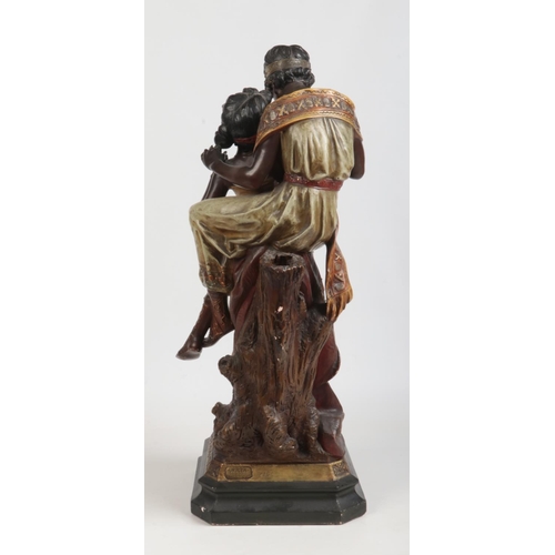 88 - A large Art Nouveau painted terracotta figure group. Odalisque and companion. Raised on a canted squ... 