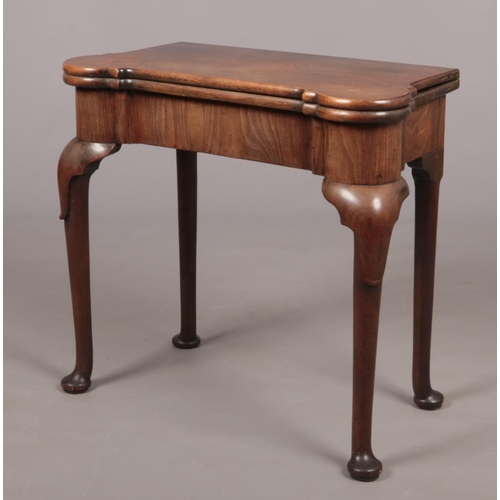 289 - A George II mahogany fold over tea table. Raised on plain cabriole supports terminating on pad feet,... 